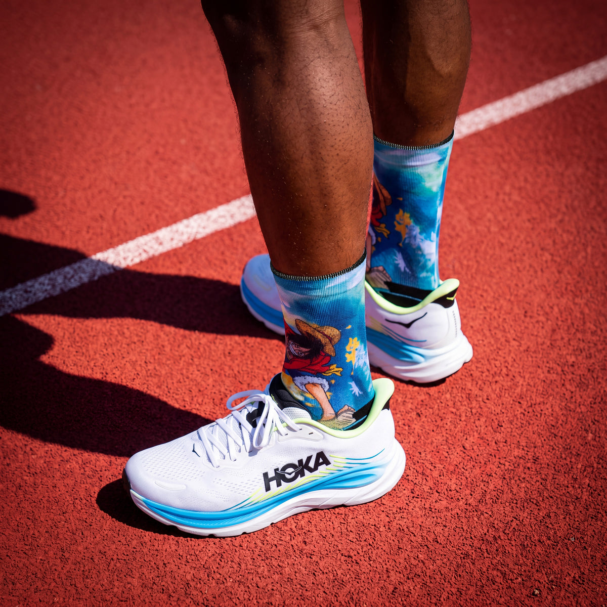 Calcetines One Piece Luffy Treasure puestos con zapatillas de running en pista de atletismo